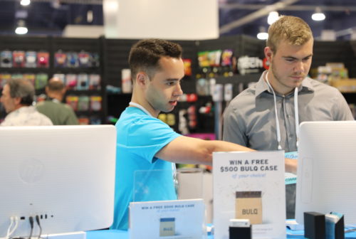 A BULQ team member assisting a visitor at our booth computer