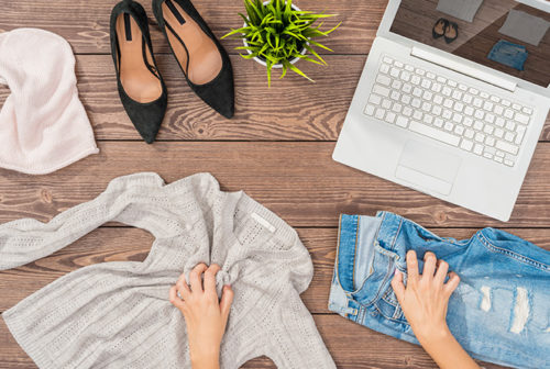Woman reselling clothes online using a laptop