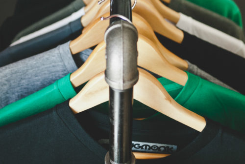 Green shirts hanging on a clothing rack
